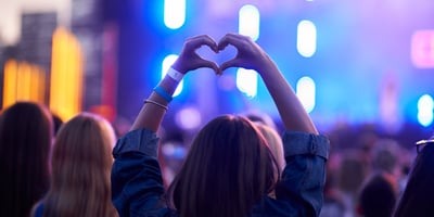 Henkilö musiikkikonsertissa tekemässä sydäntä käsillään
