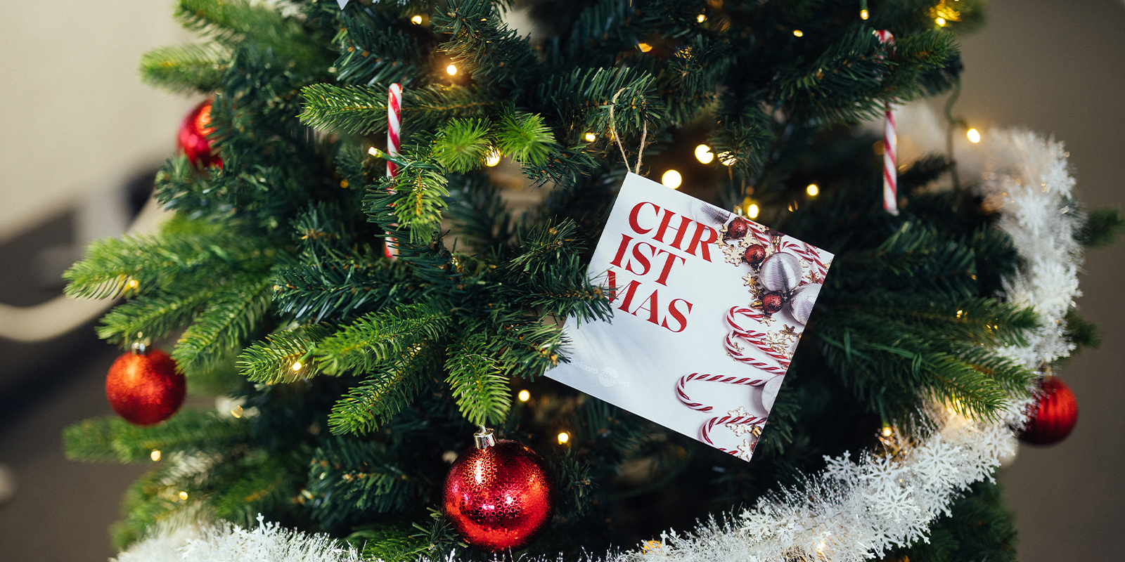 Delicard® Christmas gift card hanging in a Christmas tree