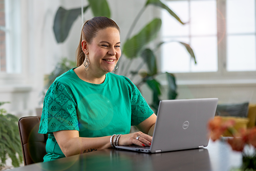 Smiling woman using laptop at a table