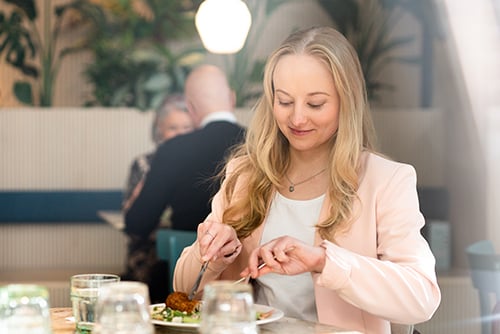 Nainen istuu ravintolassa syömässä lounasta